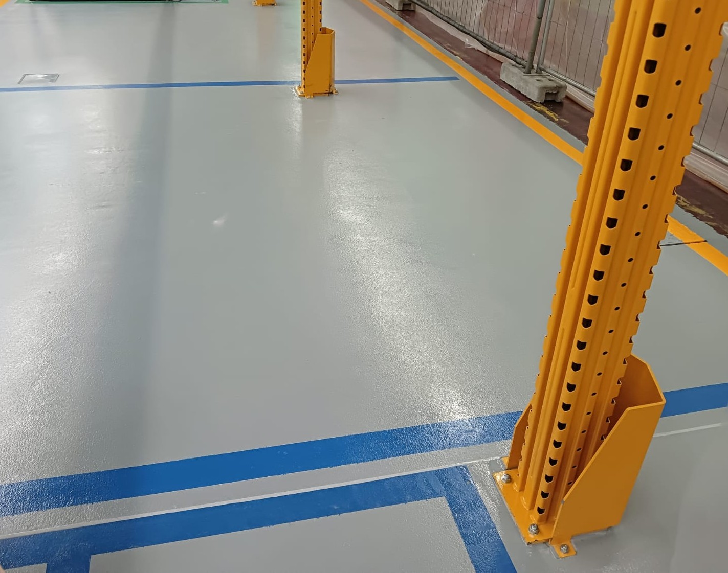area macchine presso gruppo multinazionale Amcor: pavimenti in resina ESD con bandelle di rame annegate e segnaletica blu dedicata a lunga durata